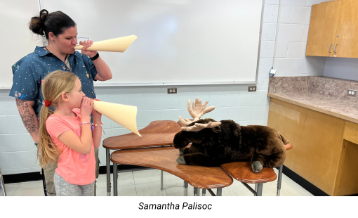 Samantha Palisoc and student with a small stuffed animal (Moose)