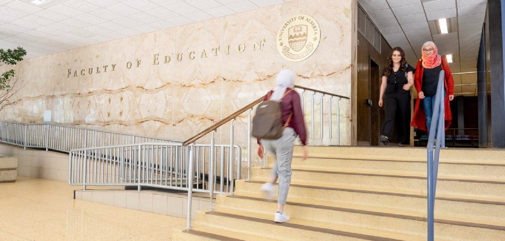 Students walking up steps in the interior of the Education Building