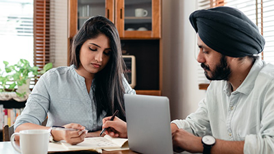 Two people sitting at desk with laptop