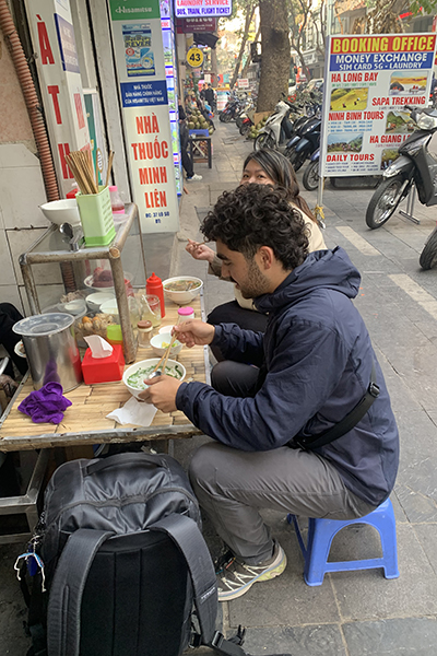 Mudher eating street food in Hanoi, Vietnam