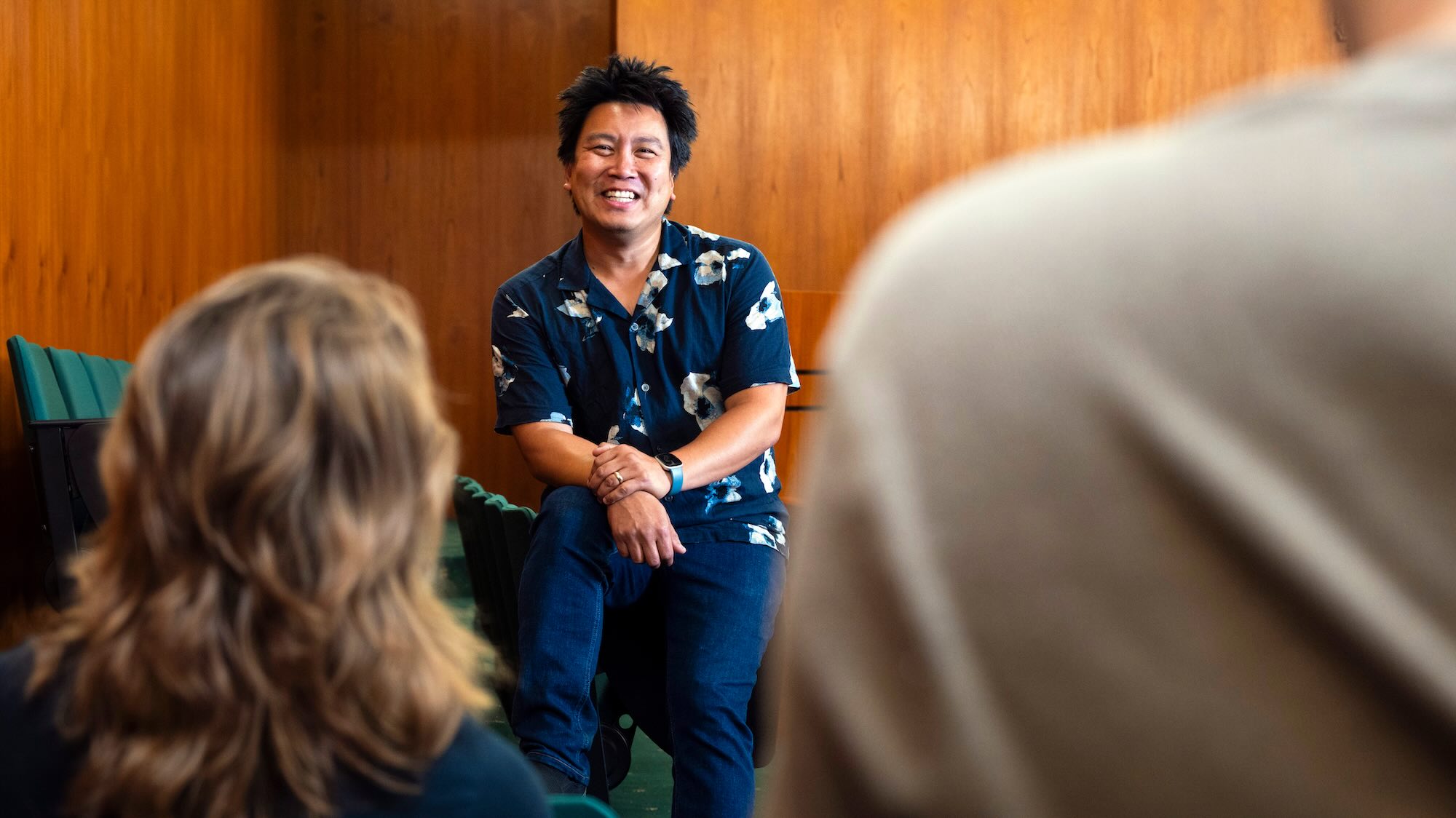 An instructor chatting with students in an auditorium