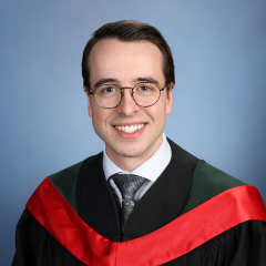 A studio portrait shows a student smiling at the camera in a black graduation gown