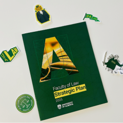 The cover of the Faculty of Law strategic plan is pictured surrounded by stickers for the law school