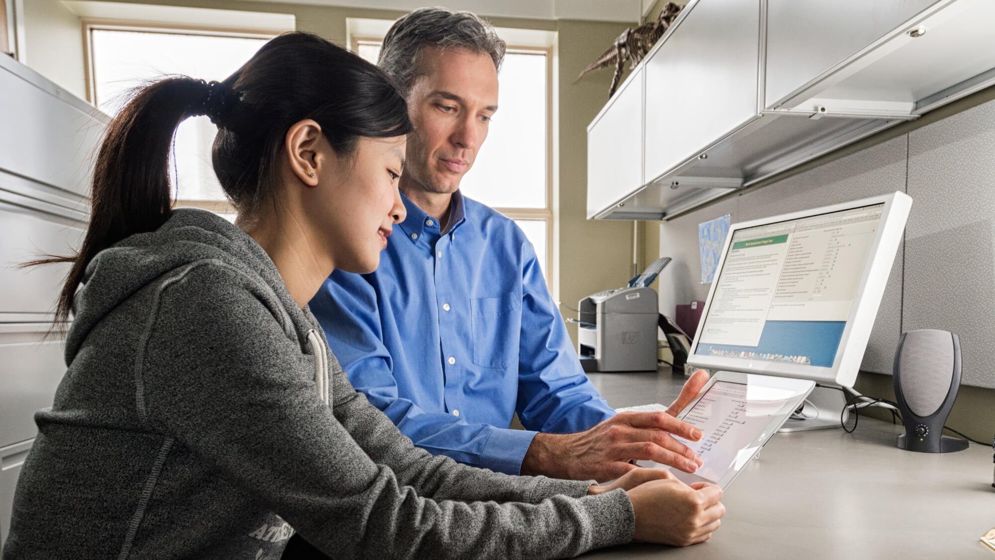 Dr, Douglas Gross and student ZiYing Lin looking at a new clinical support tool, which helps clinicians treat injured workers by suggesting a course of treatment