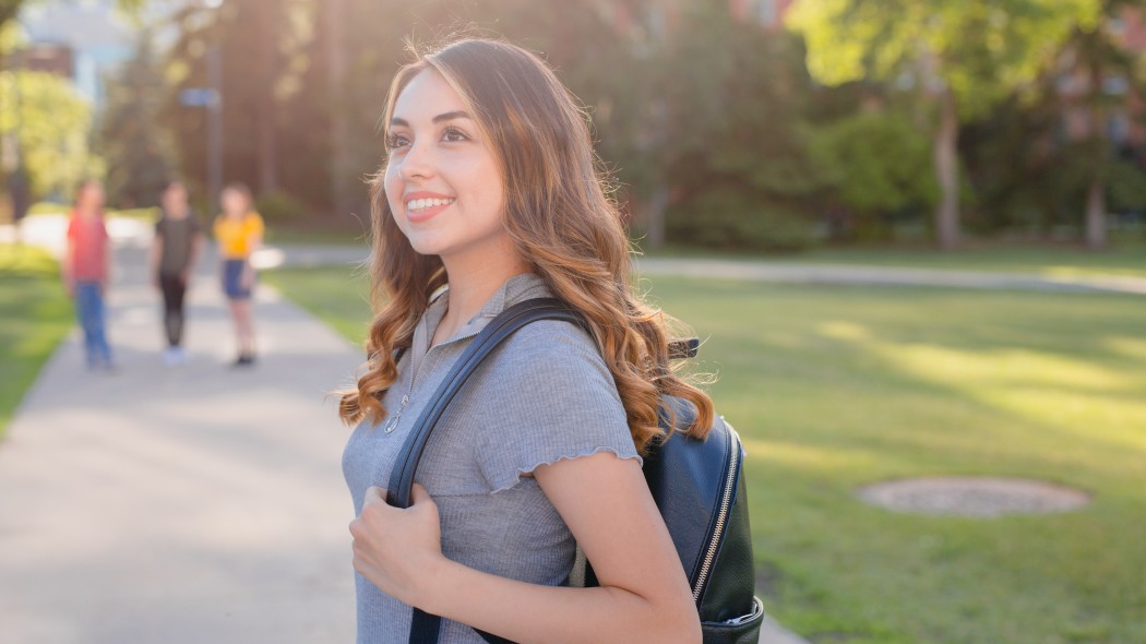 Woman wearing backpack in the quad.