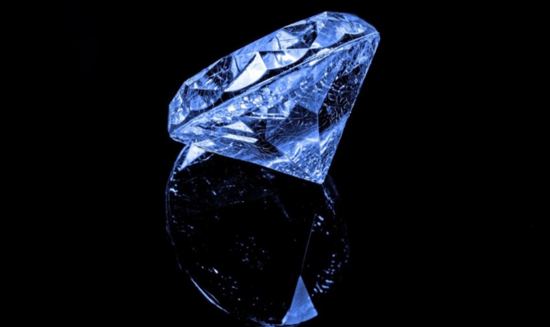 a single blue diamond on a reflective black surface